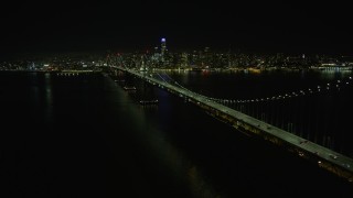 AX0174_0137 - 6K stock footage aerial video follow the Bay Bridge toward Downtown San Francisco at night, California