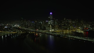 AX0174_0139 - 6K aerial stock footage of flying by the Bay Bridge and Downtown San Francisco skyline at night, California