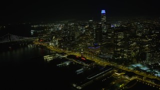AX0174_0146 - 6K stock footage aerial video fly away from Ferry Building at night, reveal Downtown San Francisco skyscrapers, California
