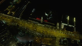 AX0174_0152 - 6K aerial stock footage tilt to bird's eye view of the Ferry Building at night, Downtown San Francisco, California
