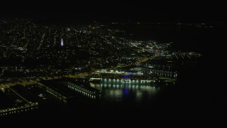 AX0174_0153 - 6K aerial stock footage of a cruise ship docked near Coit Tower at night, San Francisco, California