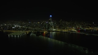 AX0174_0162 - 6K aerial stock footage fly over Bay Bridge toward Downtown San Francisco skyline at night, California
