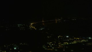 AX0174_0175 - 6K aerial stock footage approach the Golden Gate Bridge from Presidio at night, California