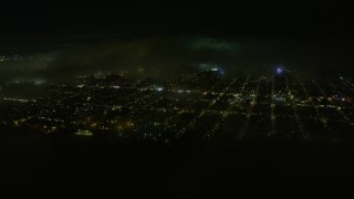 AX0174_0183 - 6K aerial stock footage of approaching the Inner Richmond District at night with fog overhead, San Francisco, California