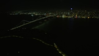 AX0174_0194 - 6K aerial stock footage of a wide view of the Bay Bridge and downtown skyline at night, San Francisco, California