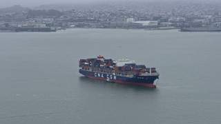 AX0175_0001 - 6K aerial stock footage flying by a cargo ship sailing San Francisco Bay, California