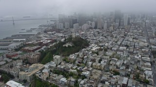 AX0175_0008 - 6K aerial stock footage of Coit Tower and Downtown San Francisco on a foggy day, California
