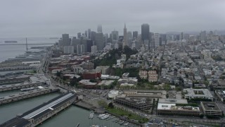 AX0175_0024 - 6K aerial stock footage flyby Coit Tower on a foggy day with Downtown San Francisco skyline in the background, California