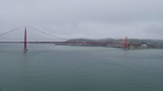 AX0175_0029 - 6K aerial stock footage of flying by the Golden Gate Bridge on a foggy day, San Francisco, California