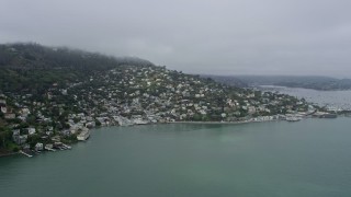 AX0175_0033 - 6K aerial stock footage of homes overlooking the bay in Sausalito on a foggy day, California