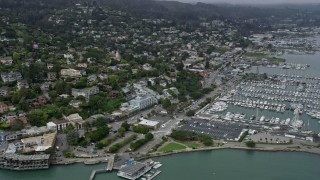 AX0175_0034 - 6K aerial stock footage of homes overlooking marinas in Sausalito on a foggy day, California