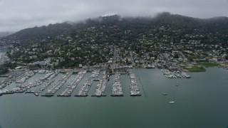 AX0175_0035 - 6K aerial stock footage of coastal neighborhoods and marinas in Sausalito on a foggy day, California