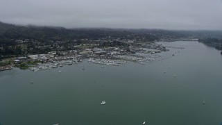 AX0175_0036 - 6K stock footage aerial video of approaching marinas by coastal neighborhoods in Sausalito on a foggy day, California