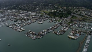 AX0175_0038 - 6K aerial stock footage of houseboats docked at a harbor in Sausalito on a foggy day, California