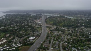 AX0175_0059 - 6K stock footage aerial video following Highway 101 through Mill Valley on a foggy day, California