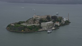 AX0175_0070 - 6K aerial stock footage of orbiting Alcatraz on a foggy day, California