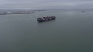 AX0175_0077 - 6K aerial stock footage flying toward a cargo ship sailing San Francisco Bay, California