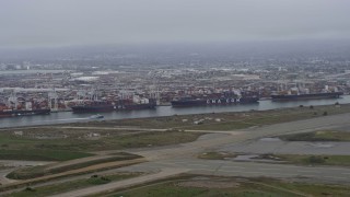 AX0175_0079 - 6K aerial stock footage flying past cargo ships docked at the Port of Oakland, California