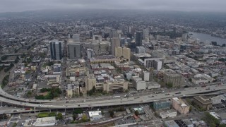AX0175_0086 - 6K aerial stock footage tilt from port to approach Downtown Oakland on a foggy day, California
