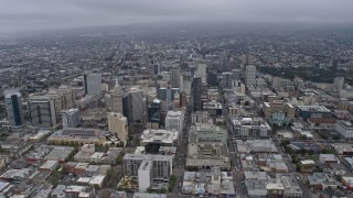 AX0175_0087 - 6K stock footage aerial video passing office buildings in Downtown Oakland on a foggy day, California