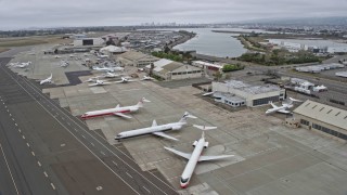 AX0175_0092 - 6K aerial stock footage of flying by aircraft parked at Oakland Airport, California