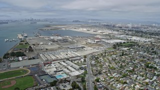 AX0175_0099 - 6K stock footage aerial video tilt from waterfront homes to reveal and approach warehouses in Alameda, California