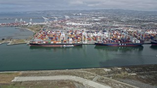 AX0175_0101 - 6K stock footage aerial video of passing cargo ships docked at the Port of Oakland, California