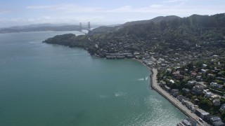 AX0175_0209 - 6K aerial stock footage of flying by Sausalito neighborhoods with the Golden Gate Bridge in the distance, California