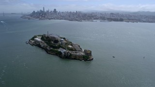 AX0175_0212 - 6K aerial stock footage approach and flyby Alcatraz with view of Downtown San Francisco skyline, California