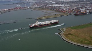 AX0175_0216 - 6K stock footage aerial video of a cargo ship and escort sailing near the Port of Oakland, California