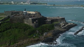 AX101_011E - 4.8K aerial stock footage of a Historic fort along the coast with clear blue water, Old San Juan Puerto Rico