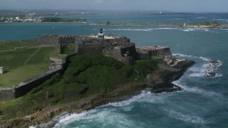 AX101_012 - 4.8K aerial stock footage of a Historic fort along the coast with clear blue water, Old San Juan Puerto Rico
