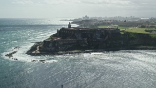 AX101_013E - 4.8K aerial stock footage of a Historic fort along the coast of clear blue water, Old San Juan Puerto Rico
