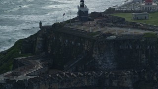 AX101_021E - 4.8K aerial stock footage of a Historic fort and lighthouse on the coast, Old San Juan Puerto Rico