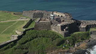 AX101_026 - 4.8K stock footage aerial video Flyover historic fort and lighthouse along blue waters, Old San Juan Puerto Rico
