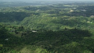 AX101_039E - 4.8K aerial stock footage of Rural homes and tree covered hills, Vega Baja, Puerto Rico