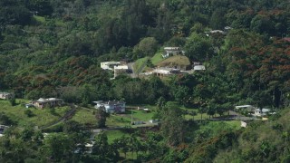 AX101_041E - 4.8K aerial stock footage of Rural homes in the tree covered hills, Vega Baja, Puerto Rico