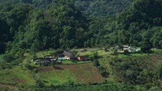 AX101_070E - 4.8K aerial stock footage of a Farmhouse nestled in at lush green forest, Karst Forest, Puerto Rico