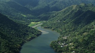 AX101_072 - 4.8K aerial stock footage of Houses on the shore of a lake among lush green forests, Lago Dos Bocas, Karst Forest