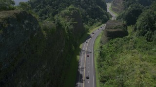 AX101_082 - 4.8K aerial stock footage Following light traffic through lush green mountains, Karst Forest, Puerto Rico