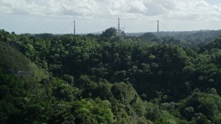 AX101_108E - 4.8K aerial stock footage of Arecibo Observatory seen from lush green mountains, Puerto Rico