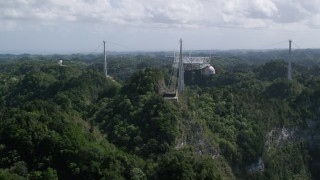 AX101_110 - 4.8K stock footage aerial video Ascending over lush jungle toward Arecibo Observatory, Puerto Rico