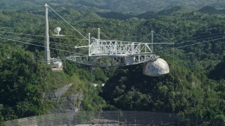 AX101_112E - 4.8K aerial stock footage of Arecibo Observatory from the top with lush green trees below, Puerto Rico
