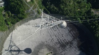 AX101_117E - 4.8K aerial stock footage Ascending above Arecibo Observatory surrounded by trees, Puerto Rico