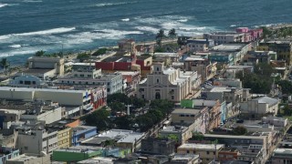 AX101_137 - 4.8K aerial stock footage of the Catedral San Felipe among buildings along the coast, Arecibo Puerto Rico