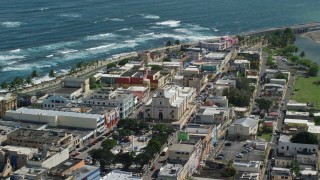 AX101_138 - 4.8K aerial stock footage of Coastal buildings and tilt down on Catedral San Felipe, Arecibo Puerto Rico