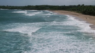 AX101_151 - 4.8K aerial stock footage Low flying over clear blue waters along a beach, Arecibo, Puerto Rico 