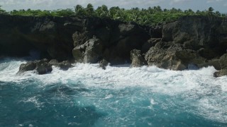 AX101_163 - 4.8K aerial stock footage of Coastal rock formations and caves on clear blue water, Arecibo, Puerto Rico 