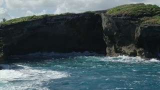 AX101_165E - 4.8K aerial stock footage of coastal sea cave in rock formations, Arecibo, Puerto Rico
