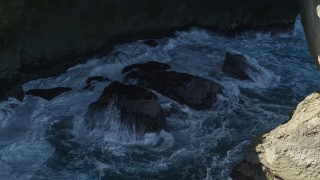 AX101_167 - 4.8K aerial stock footage of Churning water in a sea cave, Arecibo, Puerto Rico